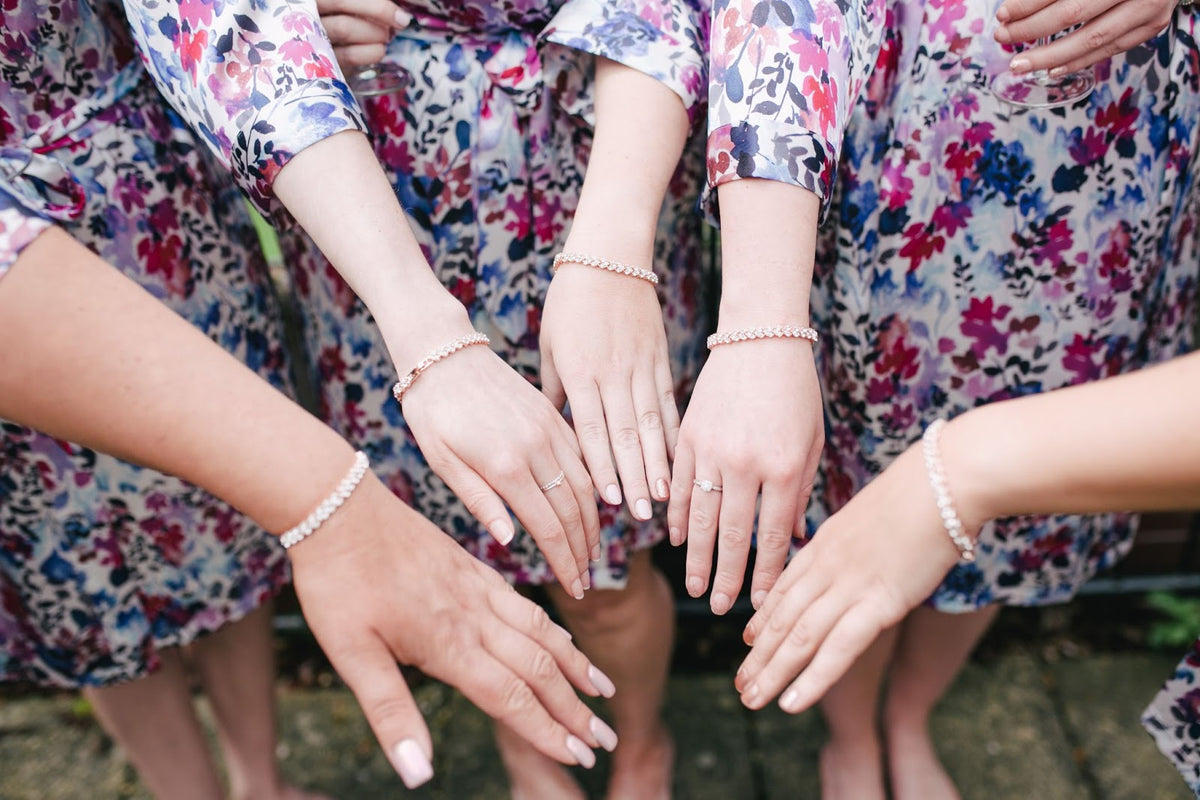 four women putting their hands together at the center photo