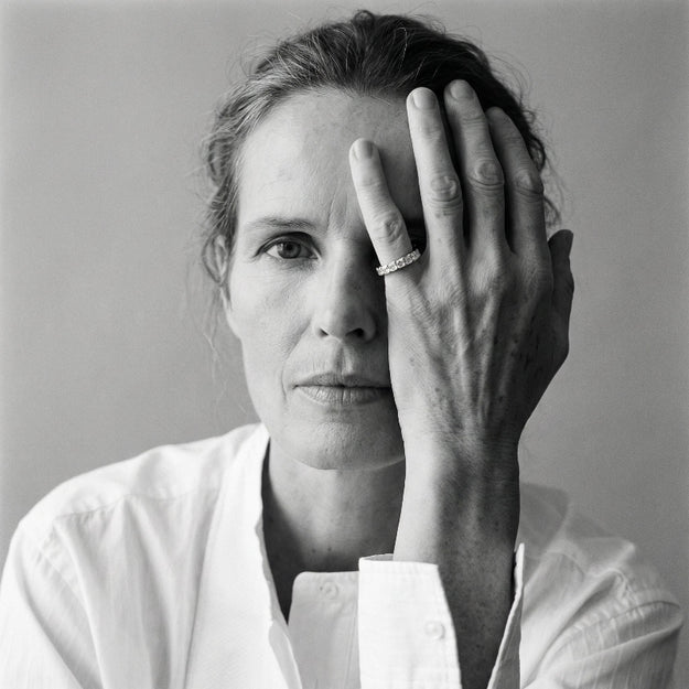Black and white portrait of a woman with her hand covering her eye.