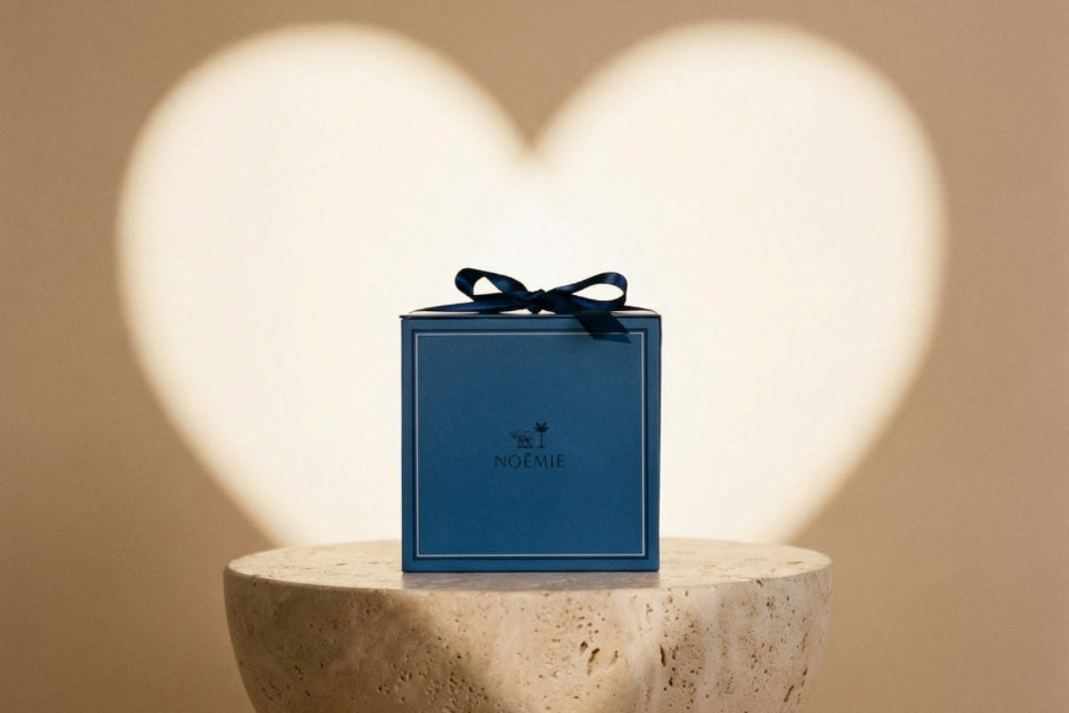 Blue gift box with a black ribbon on a stone pedestal against a heart-shaped light background