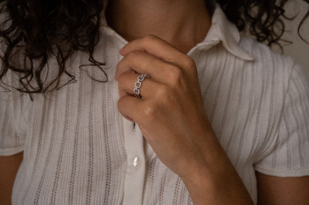 Person wearing a silver ring on a white shirt