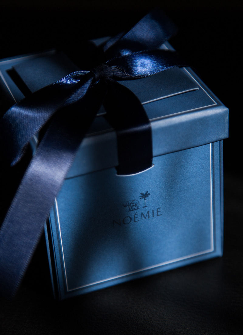 Blue gift box with a black ribbon on a dark background