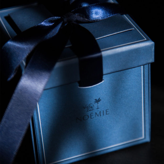 Blue gift box with a black ribbon on a dark background