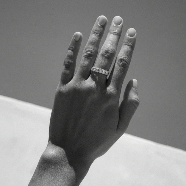 Hand with a ring on a plain background