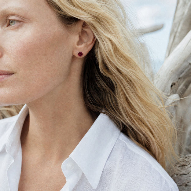 Close-up of a woman wearing a white shirt with a blurred natural background
