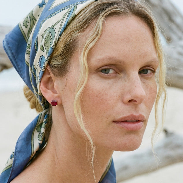 Woman wearing a patterned headscarf with a blurred natural background
