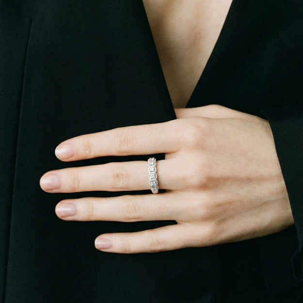 Hand wearing a diamond ring with a black background