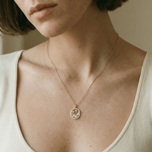 Close-up of a person wearing a delicate necklace with a small pendant.
